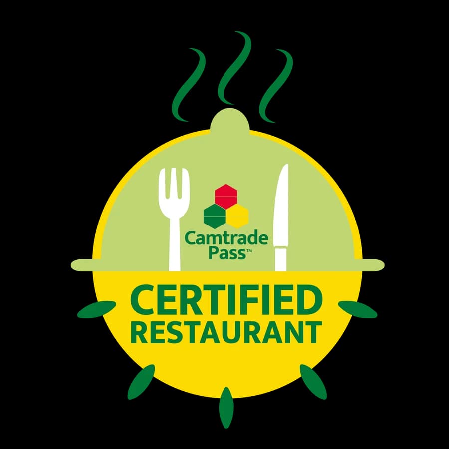 Médaillon « Camtrade Pass Certified Restaurant » : une cloche de service surmontée de fumée, encadrée d’une fourchette et d’un couteau.